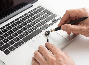 Technician carefully repairing a business laptop with visible circuit board.