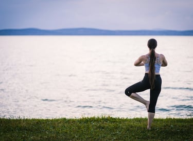 woman doing a yoga pose by the water