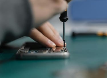 Técnico usando un destornillador de precisión para reparar la pantalla de un celular