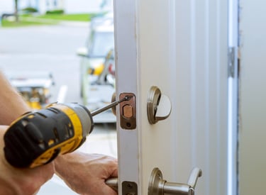 a man is using a drillet to fix a door handle