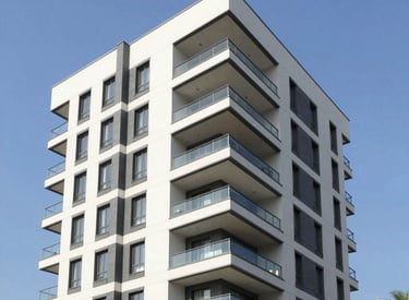 A welcoming modern home with a 'For Sale' sign in a sunny Greek neighborhood.
