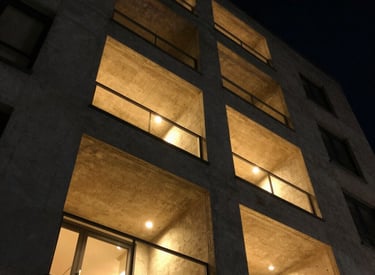 Modern renovated apartment exterior bathed in warm Greek sunlight.