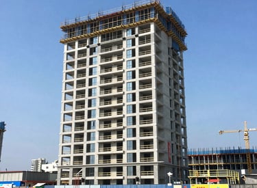 A modern family home under construction with workers installing windows on a sunny day.