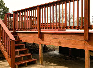 Completed residential wooden deck with stairs leading to a yard, built by Brewer Construction in Golden.