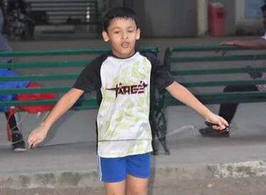 a young boy skateboarding on a sidewalk