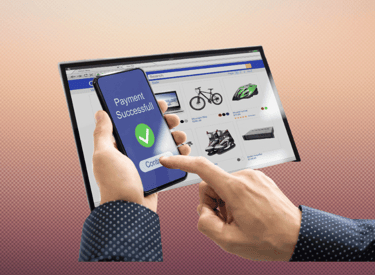 A person completing a mobile payment on a smartphone for an online shopping checkout on a tablet screen.