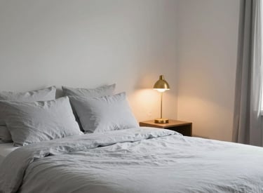 A tidy and minimalist bedroom in a Detroit recovery residence, featuring crisp light gray bedding and a warm gold lamp, evoking a sense of calm and order, professional photography.