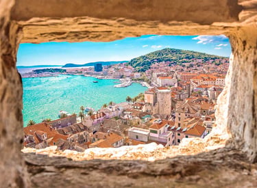 View of Split, Croatia through ancient stone window overlooking the old town and Adriatic Sea