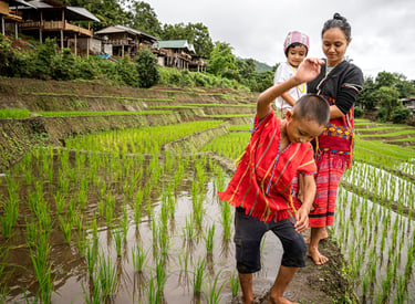 a woman and two children standing in a field