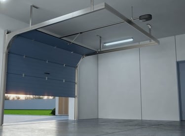 A modern, blue sectional garage door partially open in a clean, new garage, revealing an outdoor scene with green grass.