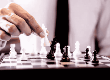 a man playing chess in a suit and tie