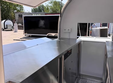 Intérieur du foodtruck demi-rond TF-DM Classic, plan de travail et rangements en acier inoxydable, sol aluminium antidérapant