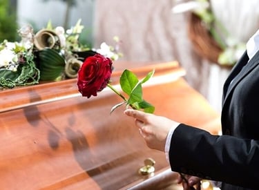 rosa vermelha sobre caixão em cerimónia fúnebre