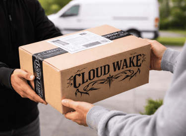Repartidor entregando una caja de envío de cartón con la marca Cloud Wake a un cliente