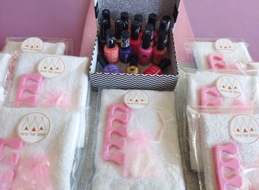 מסיבת יום הולדת ספא לילדות – מתחם טיפוח עם גיגיות להשריית רגליים, כיסאות ורודים ואווירת ספא מפנקת