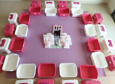 "מסיבת ספא לילדות בבית – עמדת פדיקור לילדות עם גיגיות ורודות, כיסאות קטנים ומוצרי טיפוח למסיבת יום ה