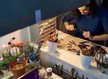 Mujer en taller de macramé realizando piezas en piedras naturales como collares 