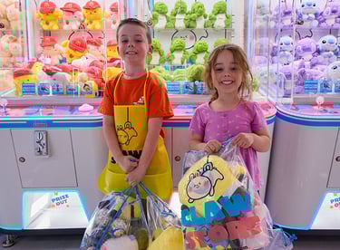 kids with plushies next to claw machines