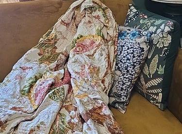 Pink floral kantha quilt on sofa