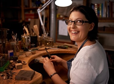 Joyera creando piezas a mano de joyería con gran alegría