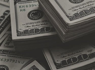 a pile of money bills and bills in front of a pile of money