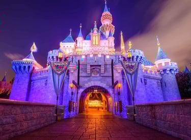 Sleeping Beauty Castle at Disneyland glowing at night - The heart of late-night mischief