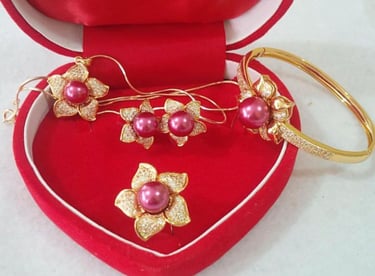 a heart shaped box with a pair of rings and a pair of earrings