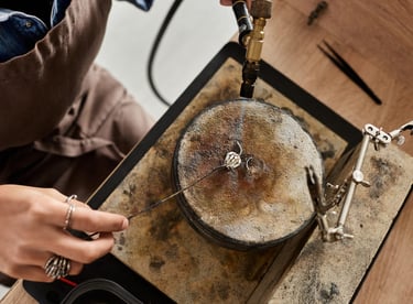 Creador de joyería con soplete de soldadura para elaborar un anillo de plata