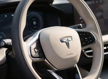 Close-up of a clean, polished steering wheel of a modern premium car, bright natural daylight, sharp focus on the leather texture, professional car photography