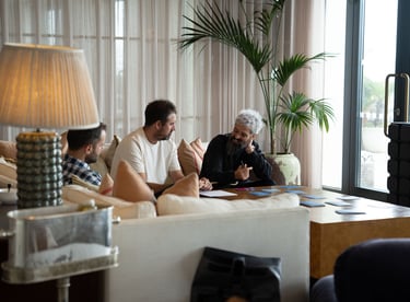 man talking to another man sitting on the sofa