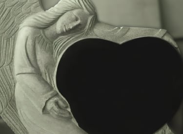 Paminklas angelas laikantis širdį