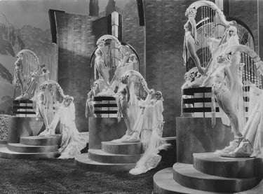 Three standing oversized harp props made of live women in a surreal Busby Berkeley musical number.