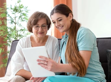 nurse and patient smiling while nurse is helping patient