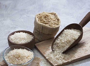 variety of rice types in jute sack and wooden scoops on a white background