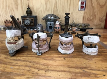 Four vintage dental phantoms on artist's workbench.