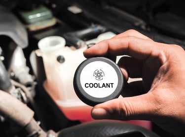 a person holding a black coolant reservoir cap
