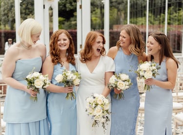 bride with her bridesmaids laughing and looking at each other