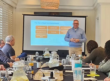 A corporate speaker gives a presentation on virtual leadership commandments to an attentive audience.