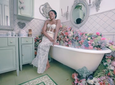 a woman in a white dress sitting in a bathtub