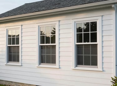 Wide daylight exterior photo of a Delaware home showing freshly painted siding, new window trim, and updated exterior details — clean lines, no people, soft afternoon light