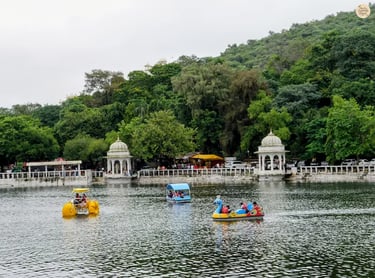 People enjoying boating and water sports at Dudh Talai Lake in Udaipur with surrounding hills in the backdrop.