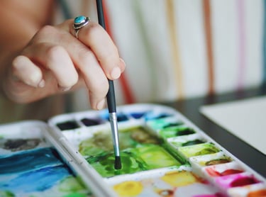 a person holding a paintbrush and painting with a brush