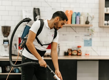 a man in a white shirt is cleaning a kitchen