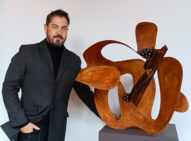 Pedro Alonso, artista y escultor contemporáneo, junto a una obra en su estudio.