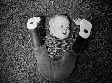 Zdjęcie chłopca w kaloszach na trawie