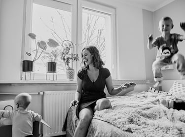 Czranobiała fotografia reportażowa przedstawiająca mamę z dwójką synów.