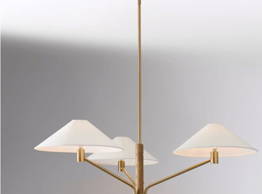 Modern brass and wood chandelier featuring three white tapered shades for elegant dining room lighting.