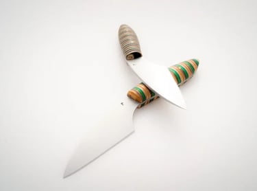 Two handmade Kiridashi knives with colorful recycled skateboard wood handles on a white background.