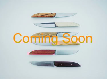 Sereral table knives handcrafted in carbon steel on a white background