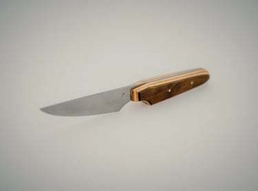 Handcrafted fixed blade table knife with a sharp steel blade and custom wood handle.